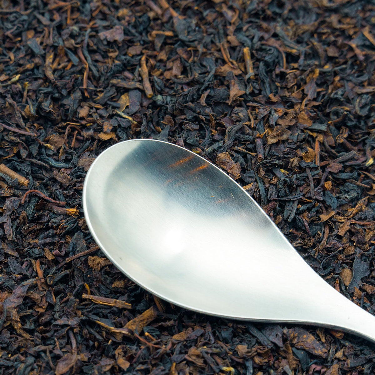 A spoon rests on a pile of Decaffeinated Earl Grey tea