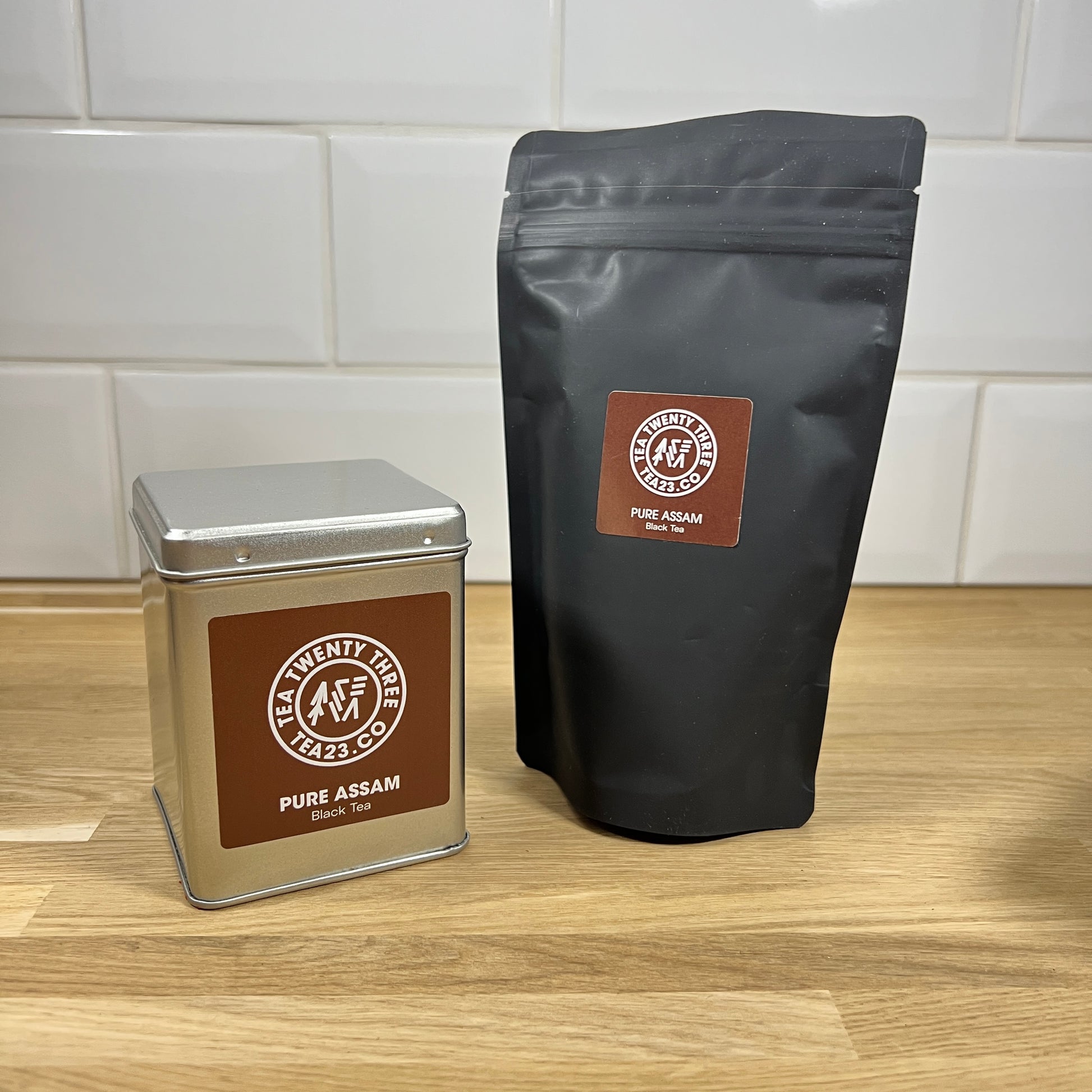 A silver tin and black pouch of Assam loose leaf black tea