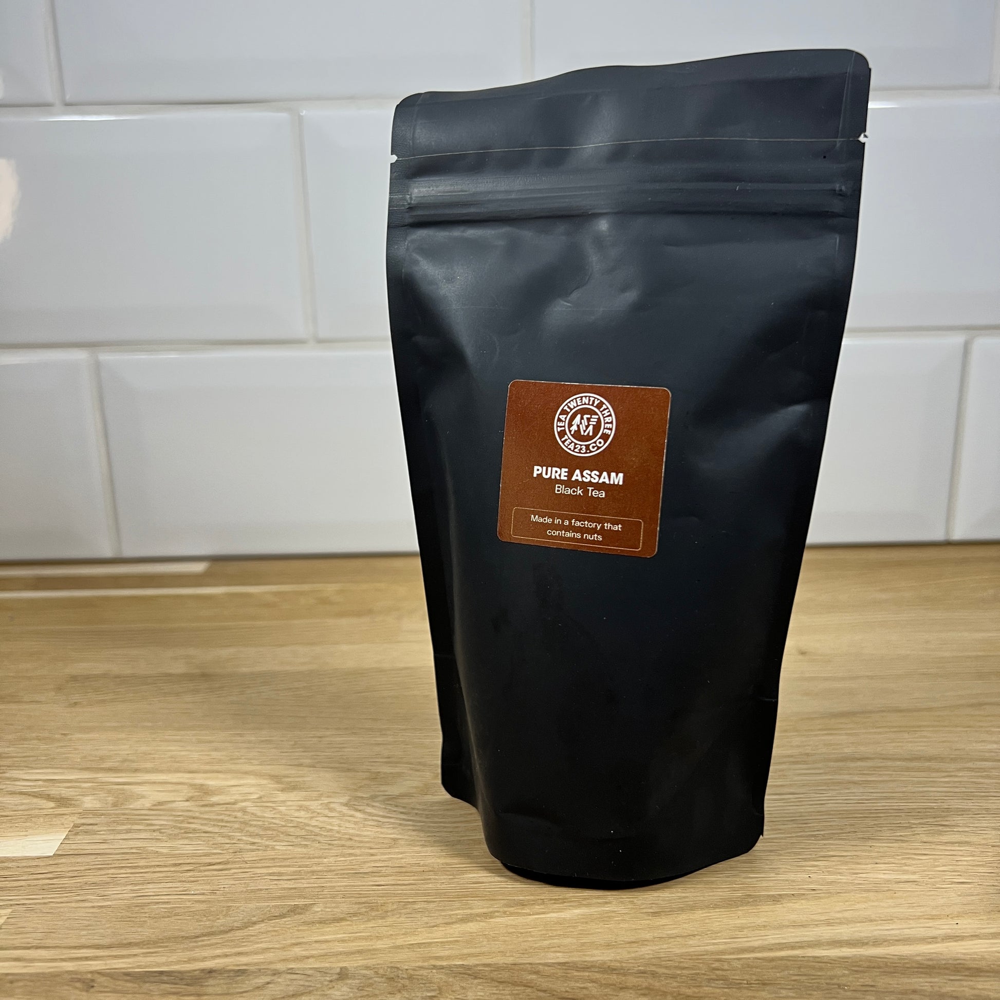 Black pouch of Assam loose leaf tea on a table