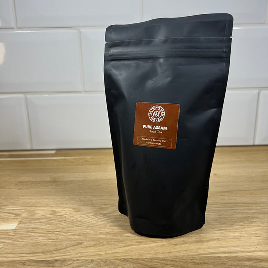 Black pouch of Assam loose leaf tea on a table