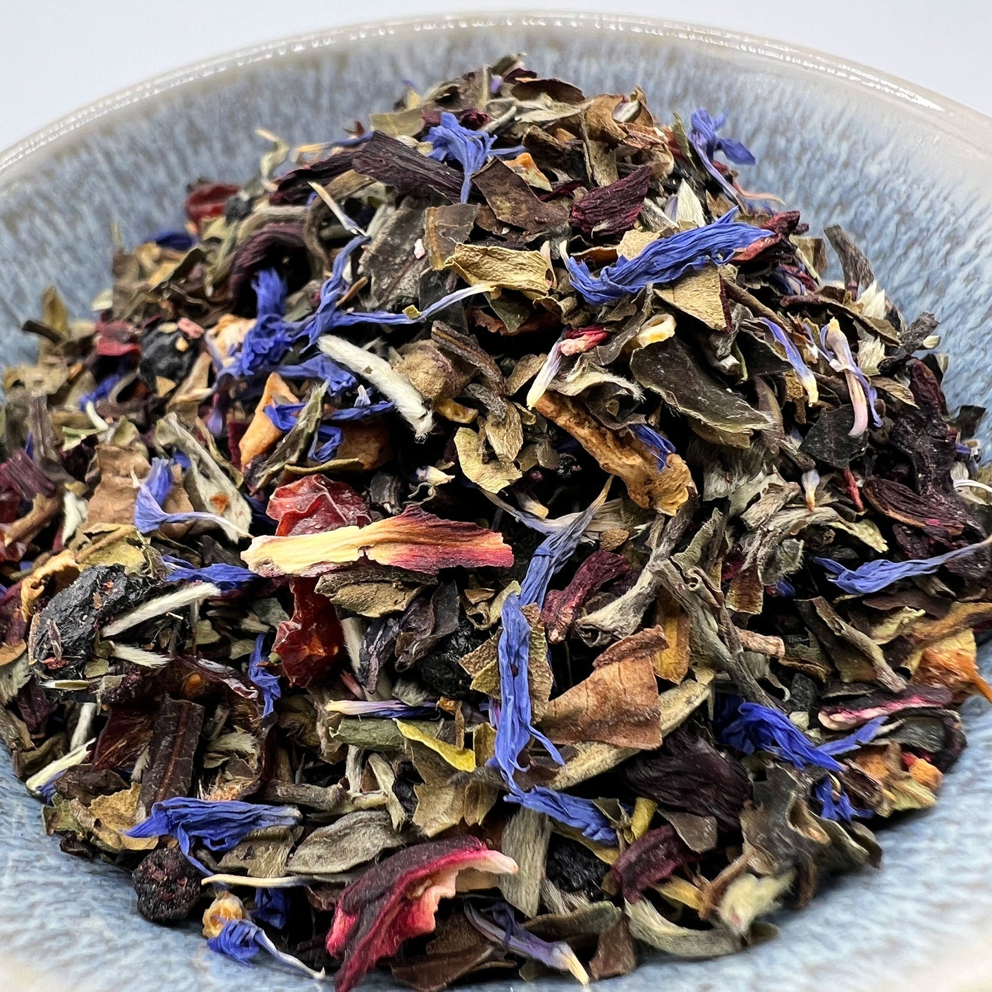 Assorted dried tea leaves with colorful petals in a bowl