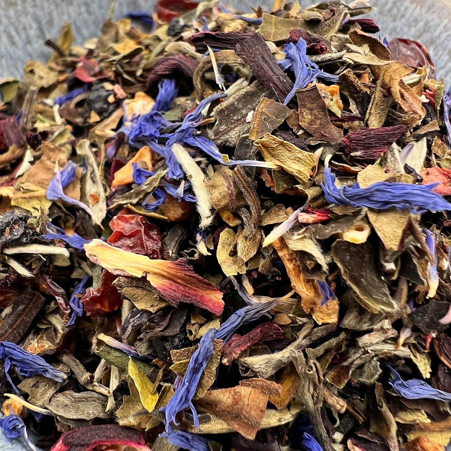 Assorted dry white loose tea and blue flowers in a pile