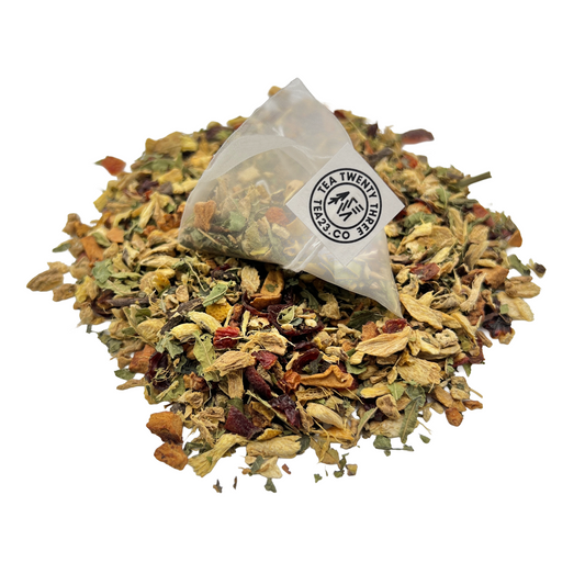 A lemon and ginger tea bag on a pile of loose leaf herbal tea