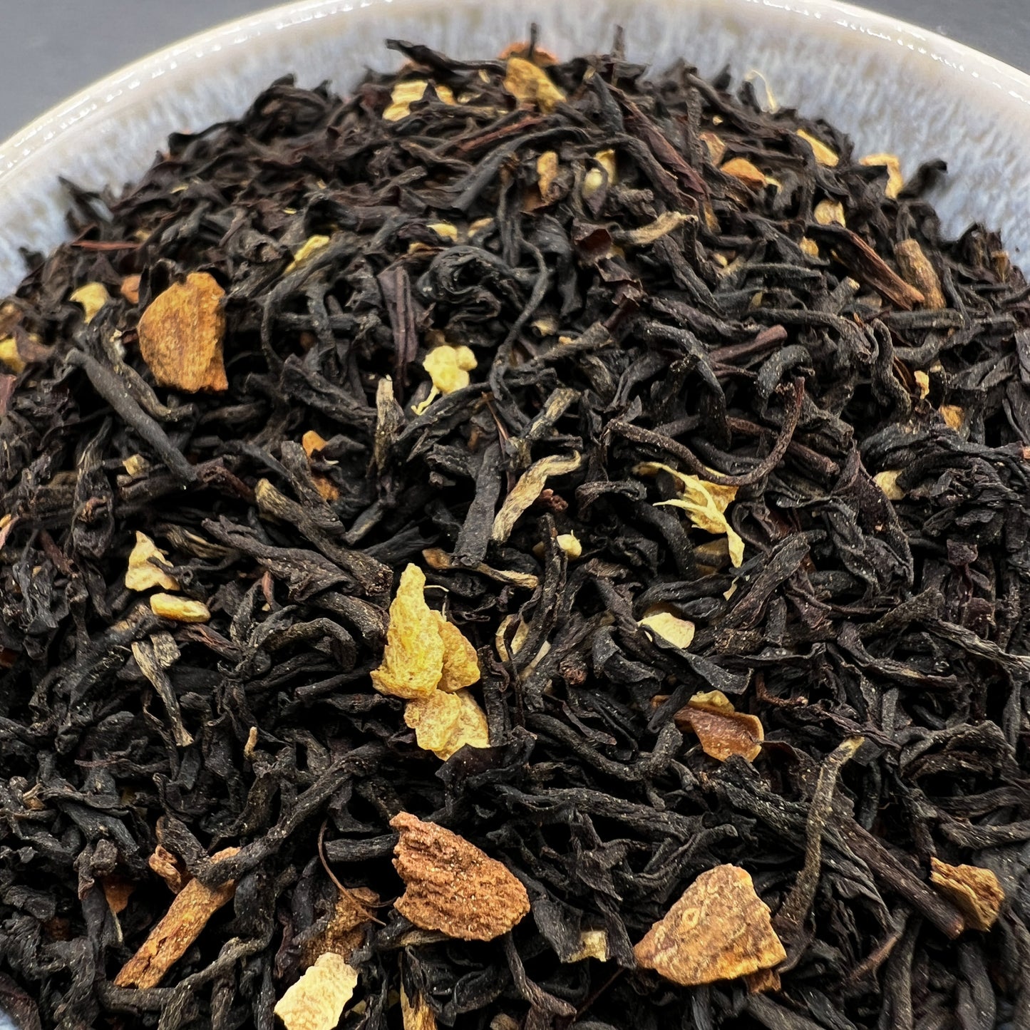 Close-up of black tea leaves with with spices in a dish
