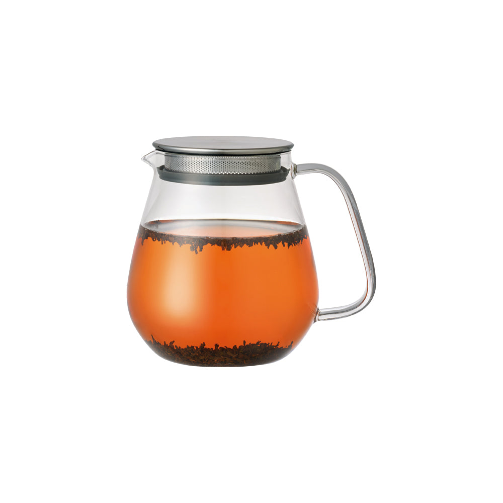 A glass teapot with a stainless steel lid brewing tea
