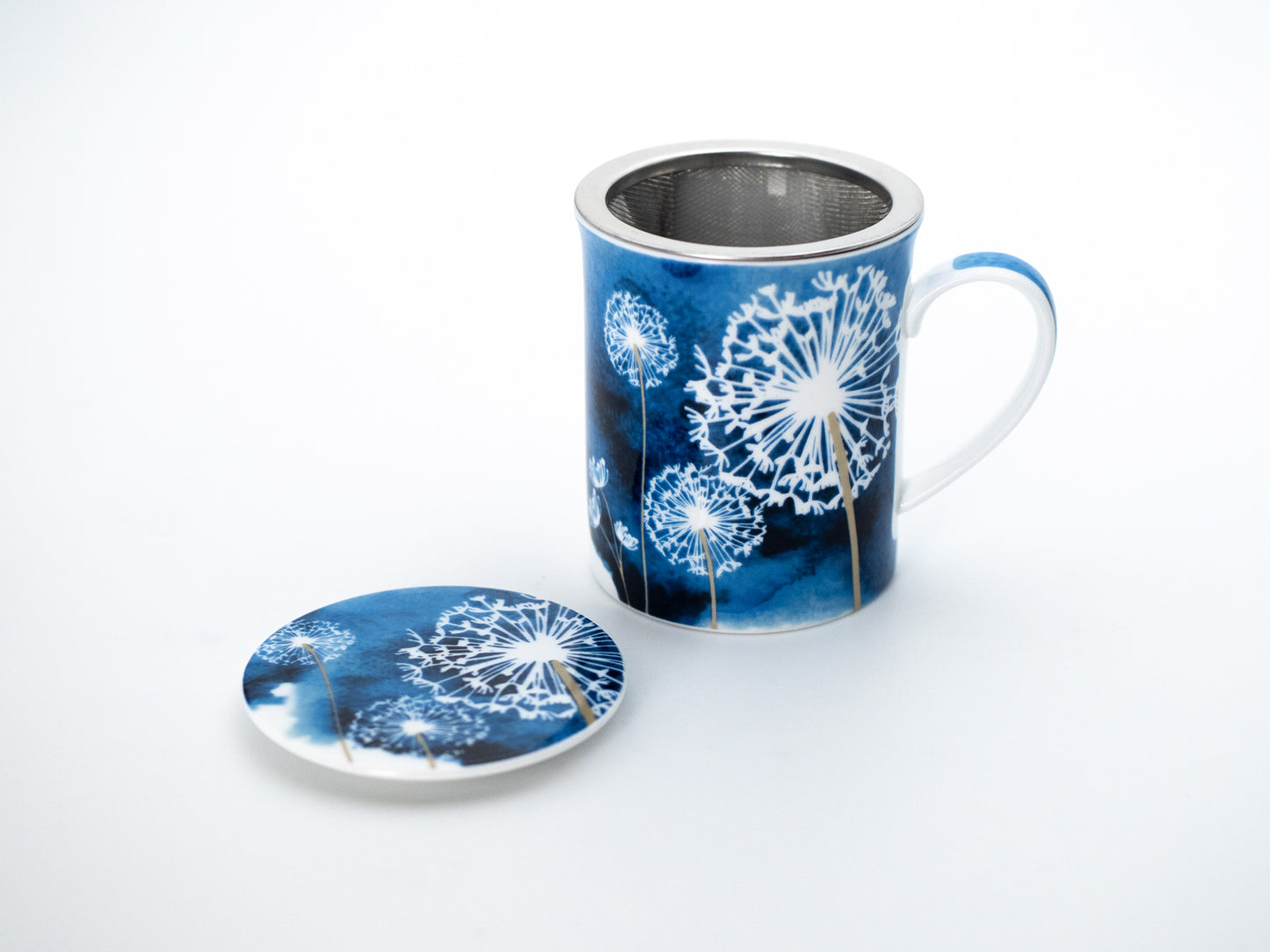 Blue dandelion porcelain infuser mug and stainless steel infuser basket stand next its porcelain lid