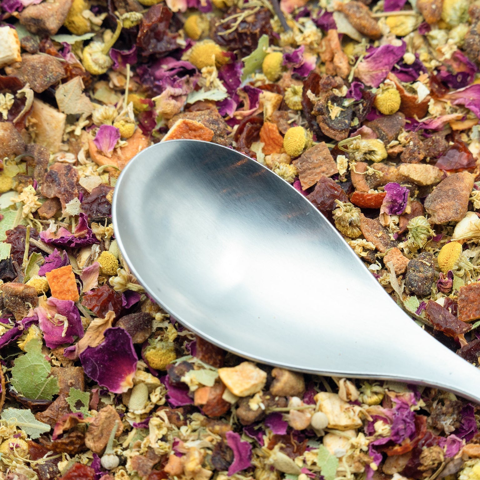 Close up of Chamomile & Pear fruit tea with a silver tea caddy spoon resting on top
