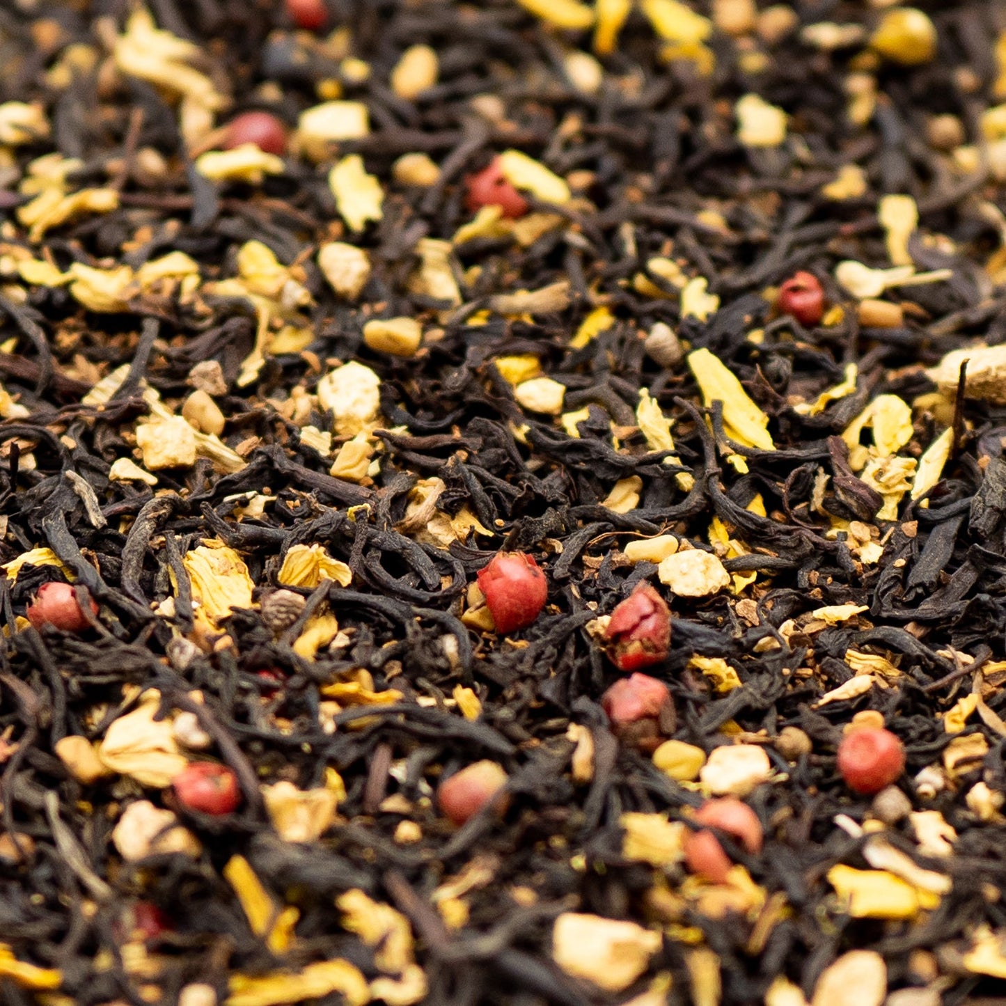 A close up of loose leaf Aromatic Chai tea with red pepper corns and sunflower petals
