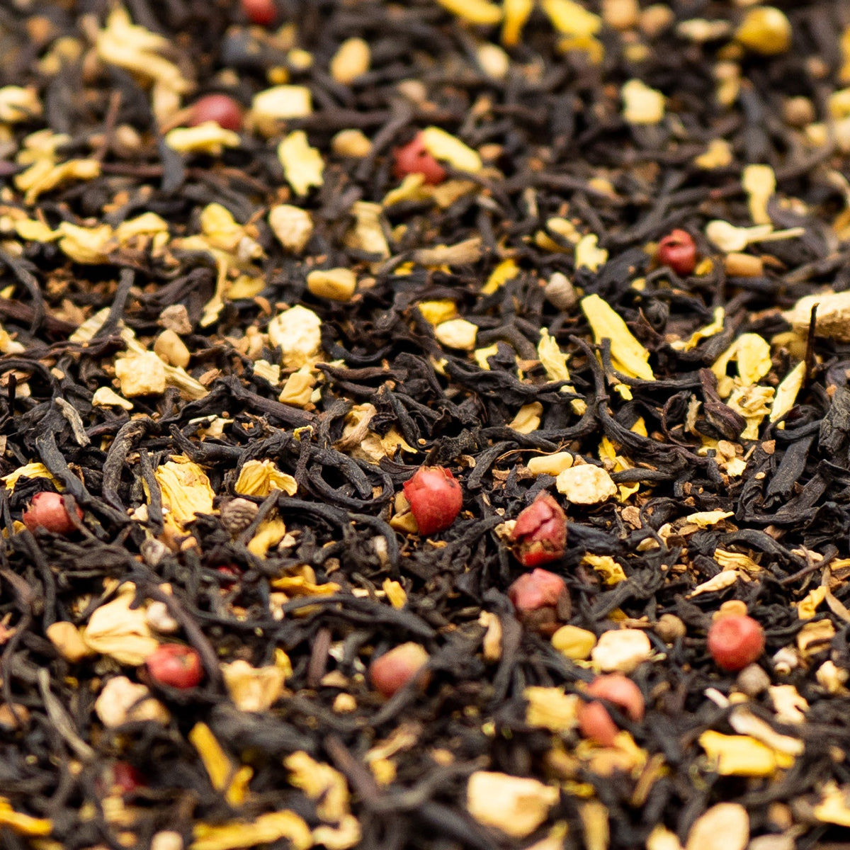 A close up of loose leaf Aromatic Chai tea with red pepper corns and sunflower petals
