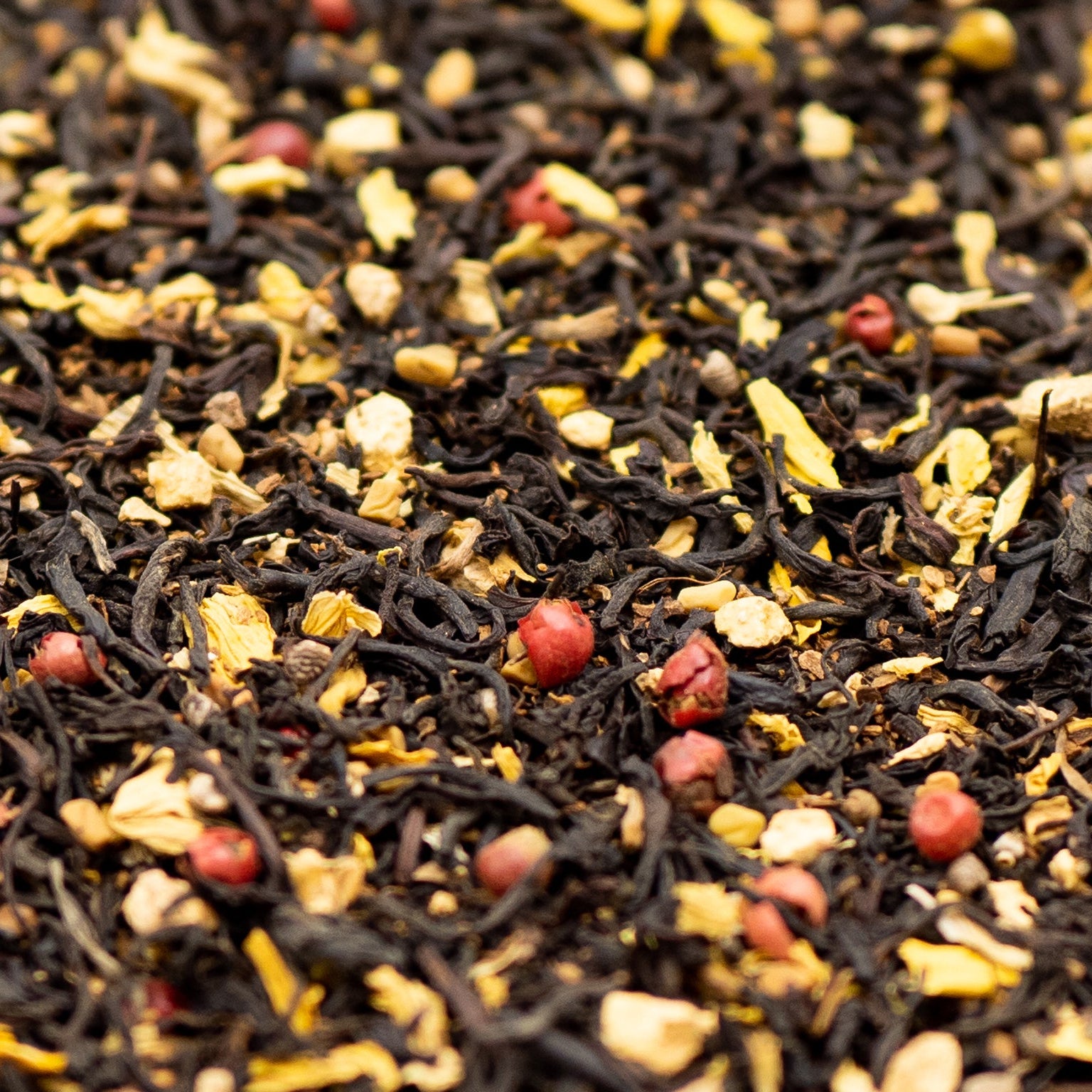 A close up of loose leaf Aromatic Chai tea with red pepper corns and sunflower petals