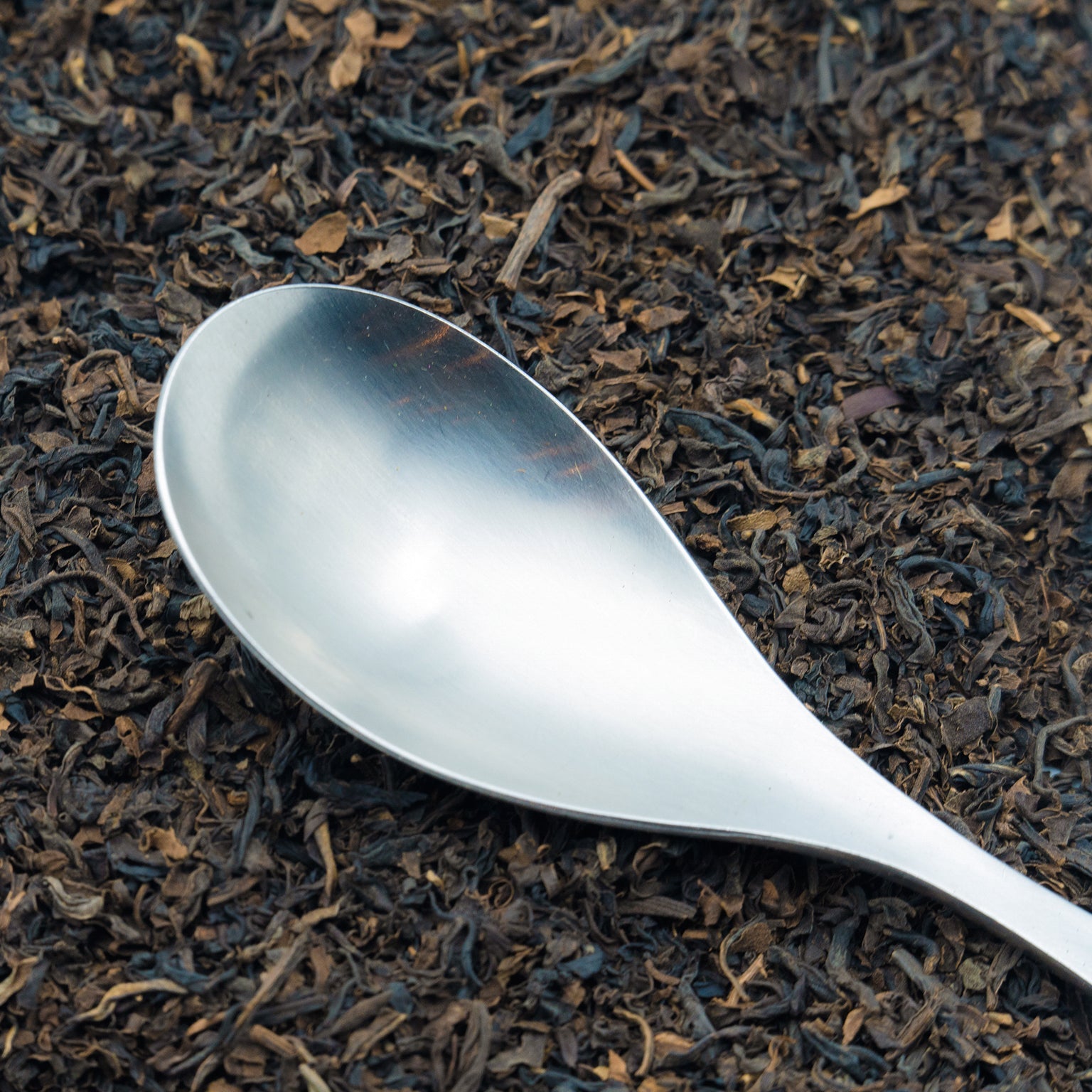 Decaffeinated Assam loose leaf black tea with a spoon on top