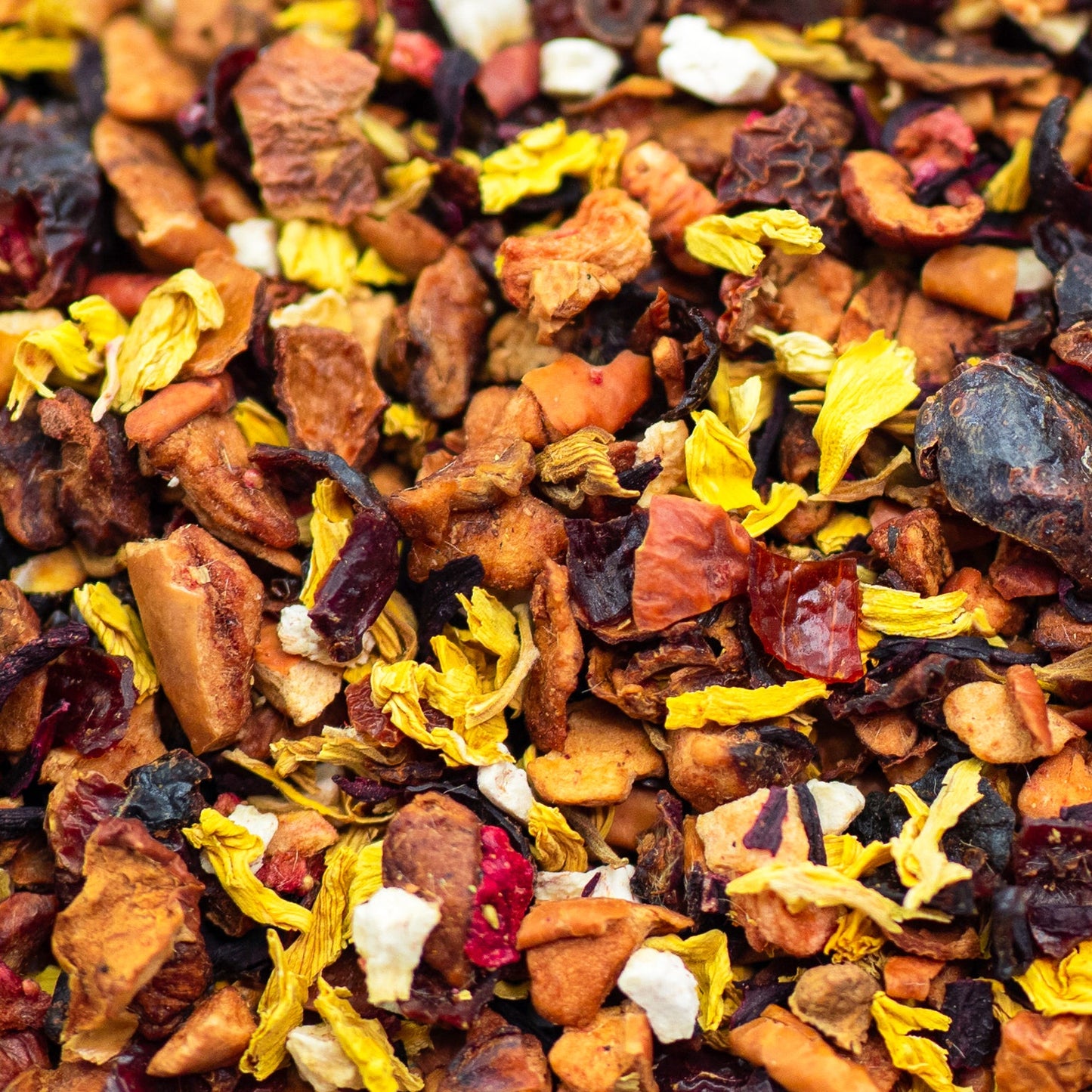 A close up of banana, strawberry, hibiscus, rosehip, sun flower petals, and apple pieces