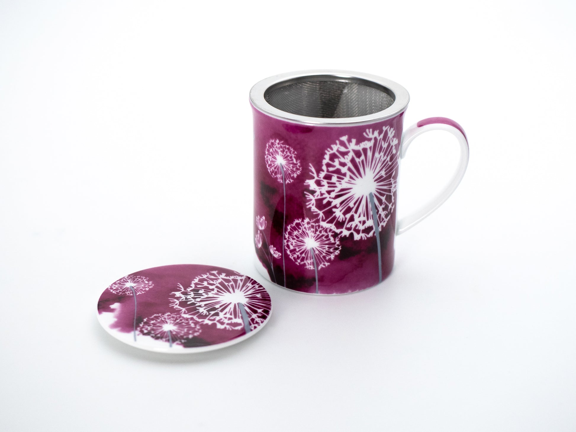 Pink dandelion porcelain infuser mug and stainless steel infuser basket stand next its porcelain lid