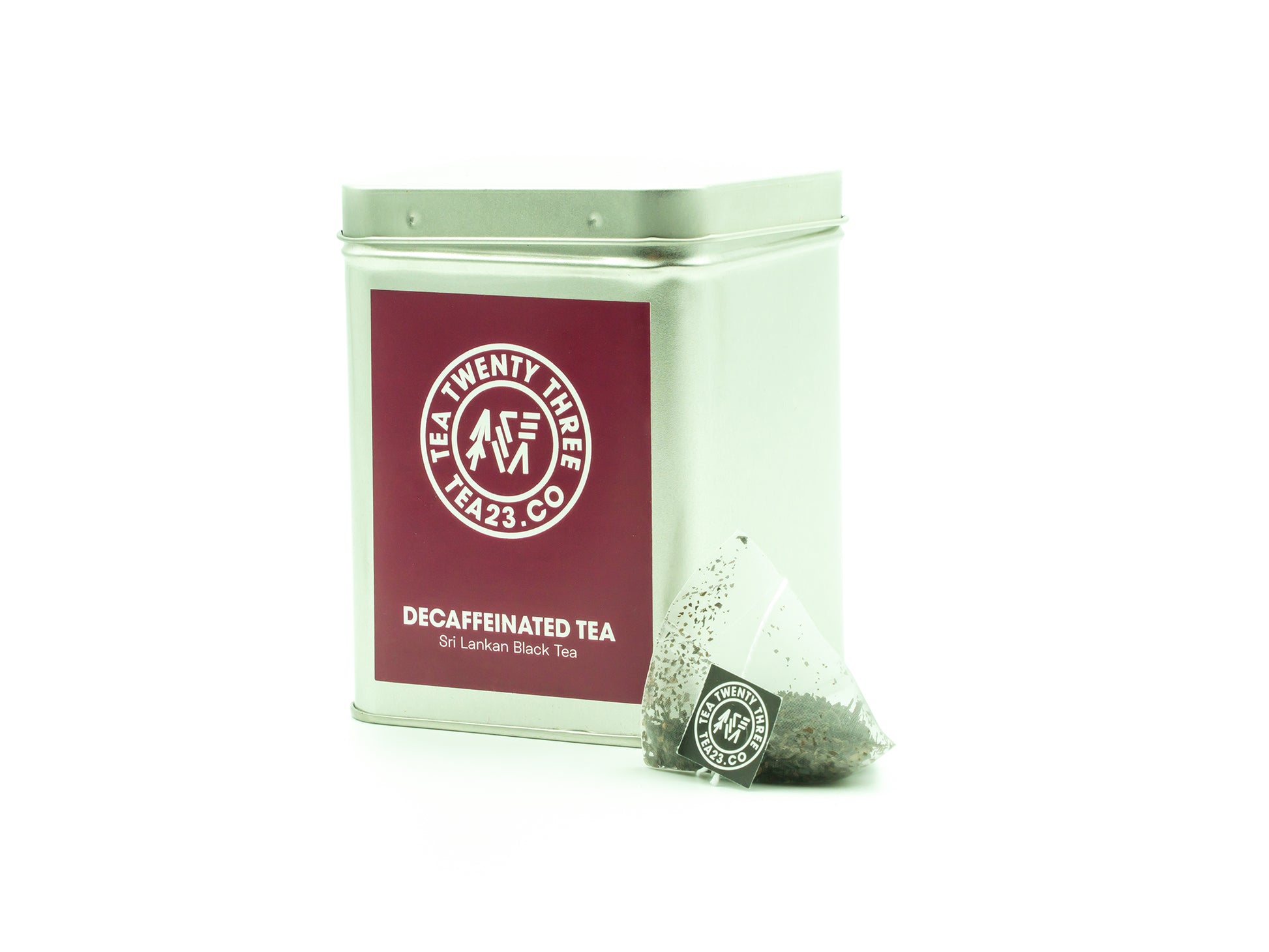 Decaffeinated Sri Lankan Black Tea in a pyramid tea bag from TEA23 sits in front of a tea caddy