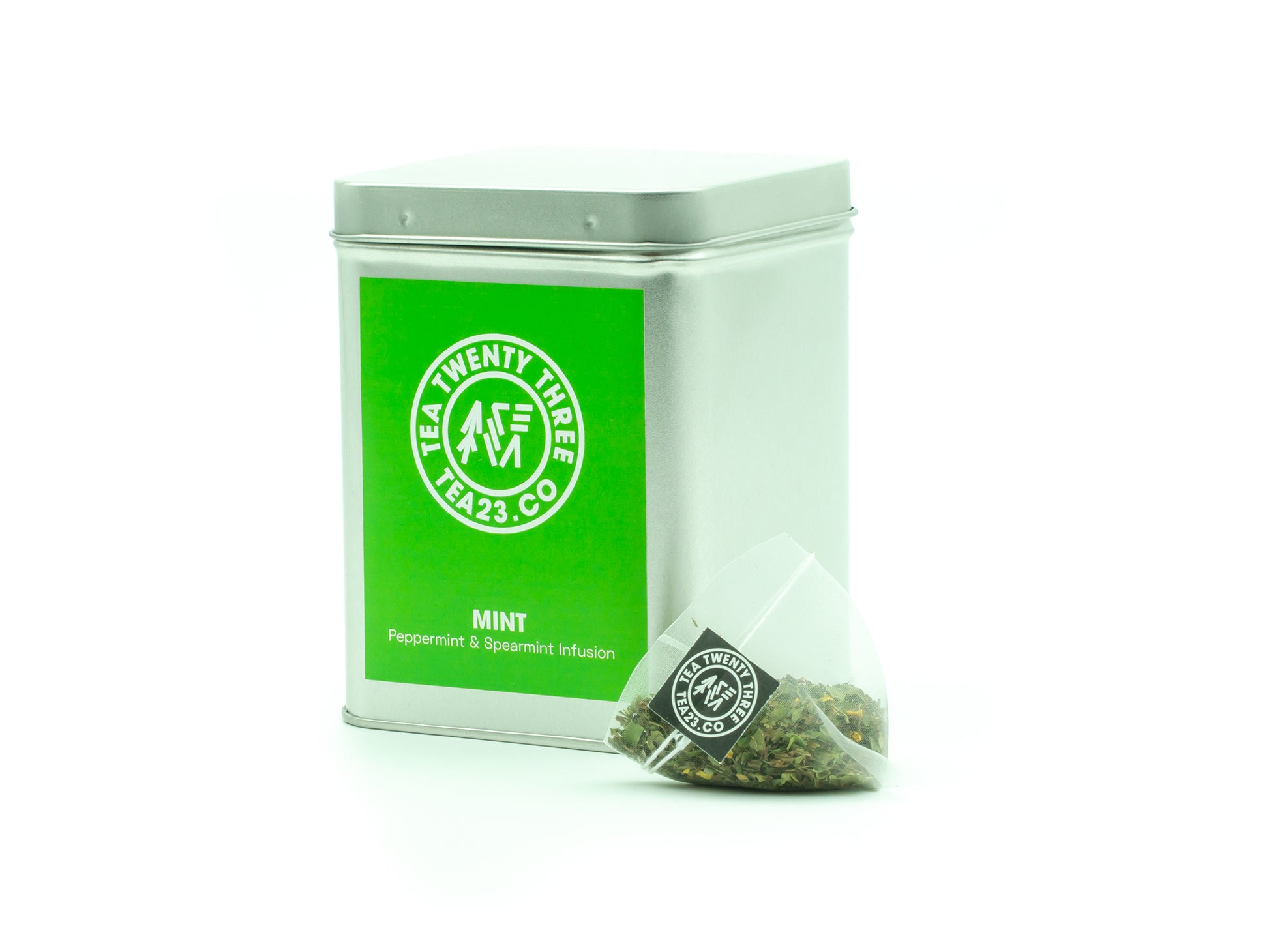 A Mint Tea pyramid tea bag from TEA23 sits in front of a tea caddy