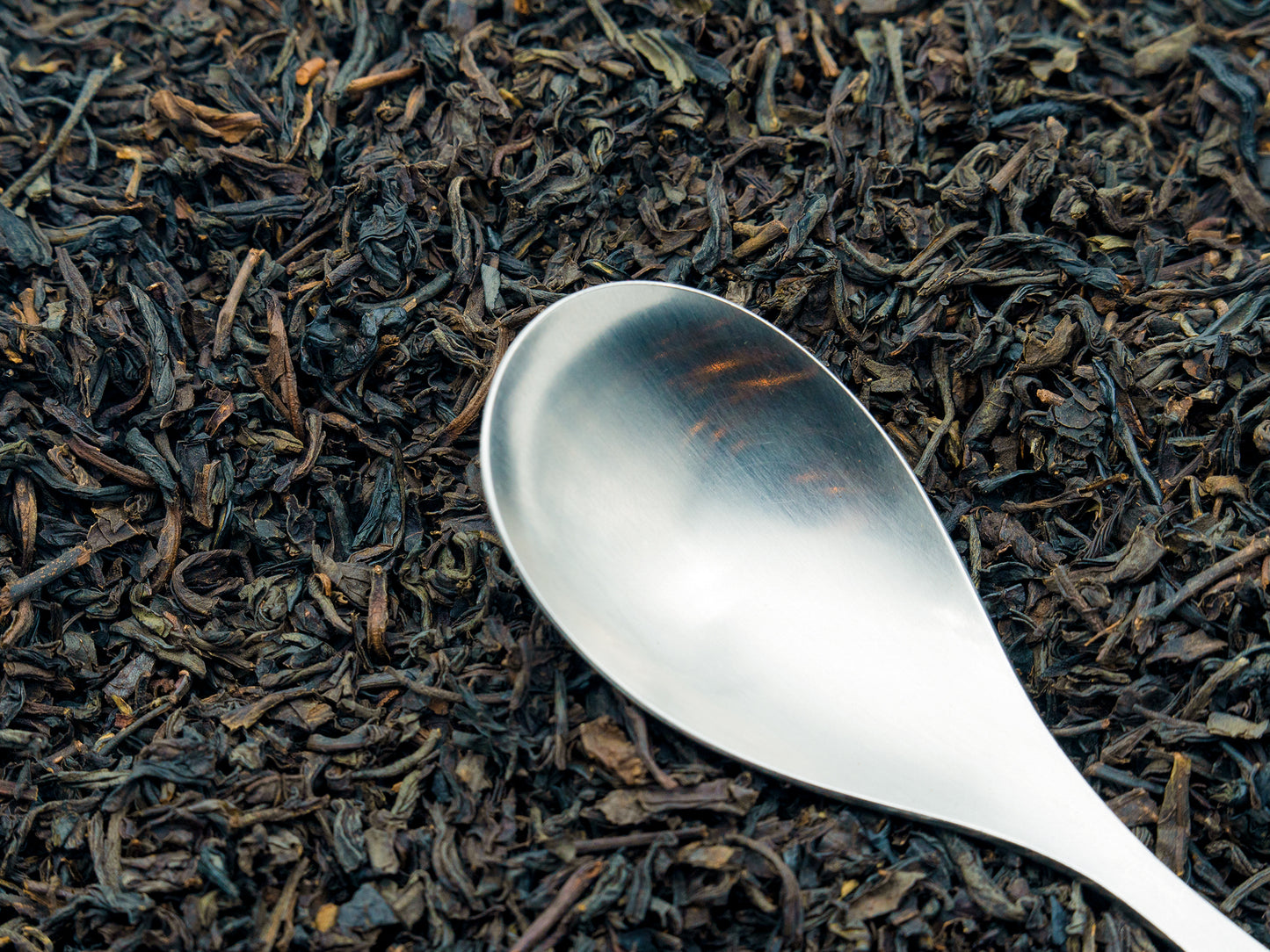 Loose Lapsang Souchong black tea from TEA23 with a spoon resting on top