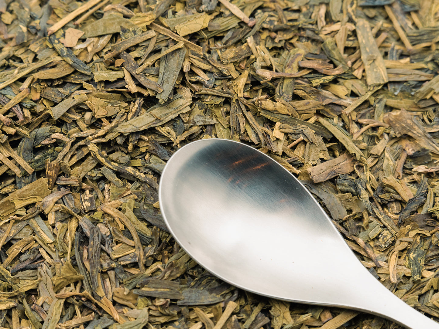 Loose Lungching Green Tea from TEA23 with a spoon resting on top